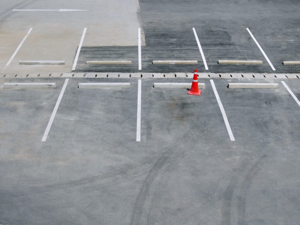 Single Orange Plastic Traffic Cone at Vacant Parking Lot